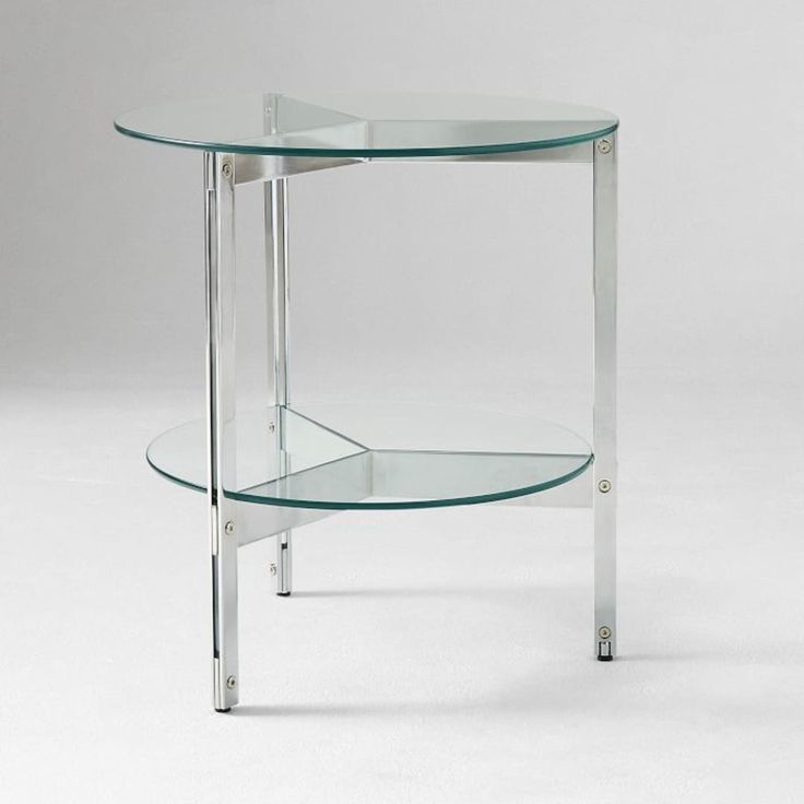 a glass table with metal legs and a shelf on one side that has a round glass top