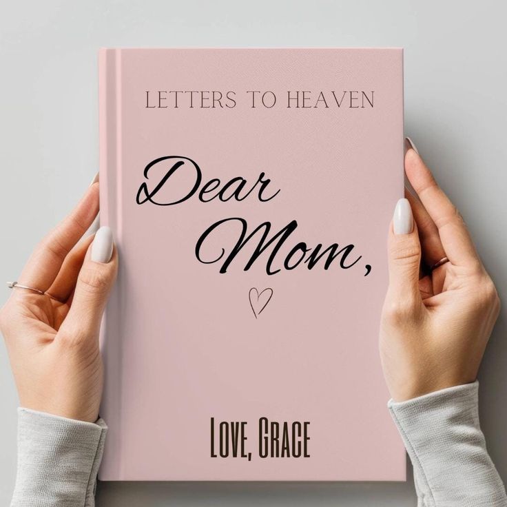 two hands holding a pink book that says, letters to heaven dear mom love grace