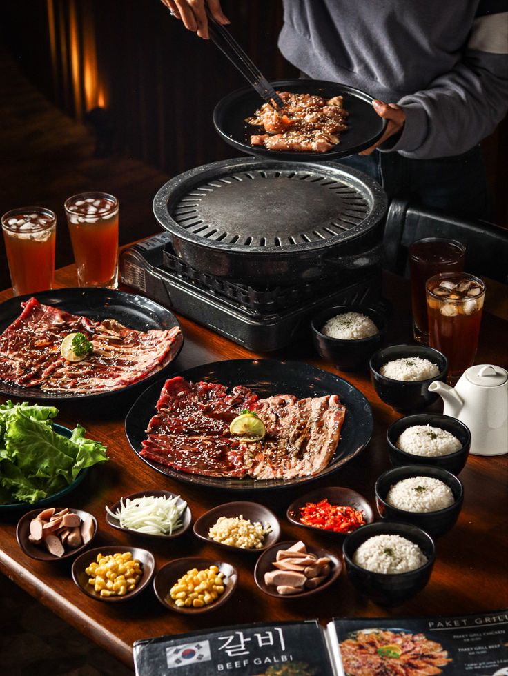 a table topped with plates and bowls filled with food next to an open pizza oven