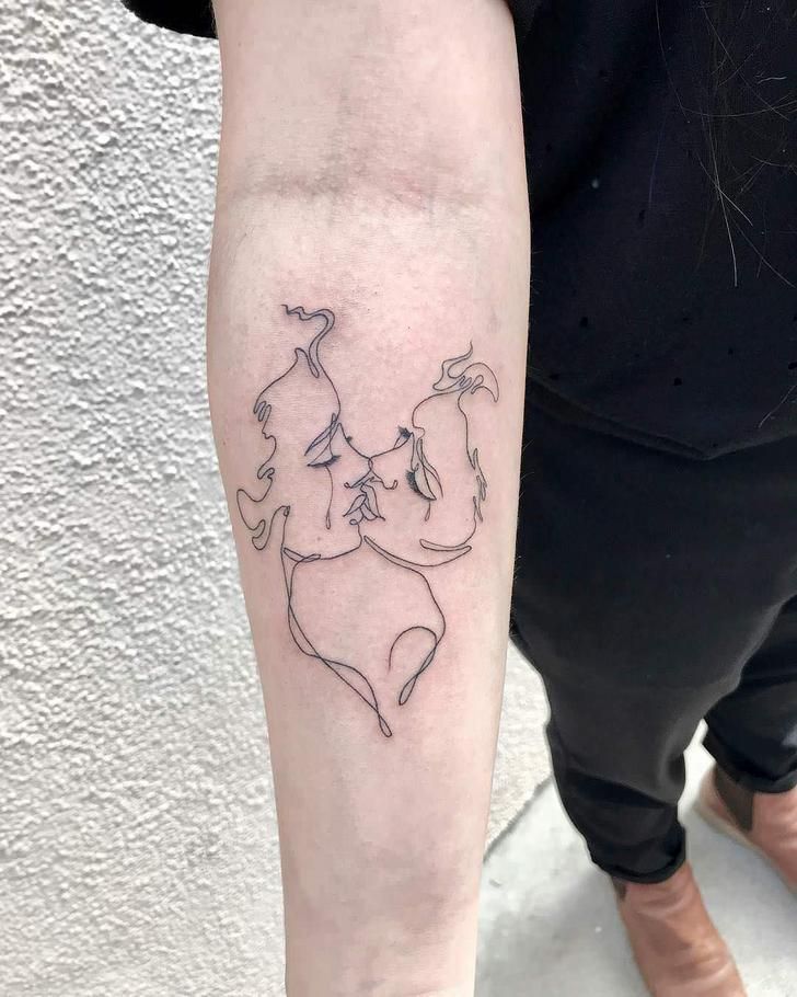 a woman's arm with a tattoo on it that shows two people hugging each other