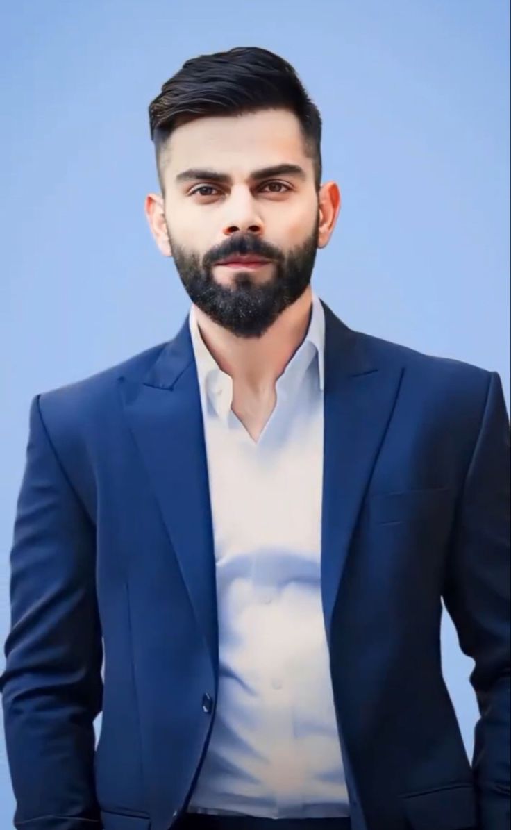 a man with a beard wearing a blue suit and white shirt is looking at the camera