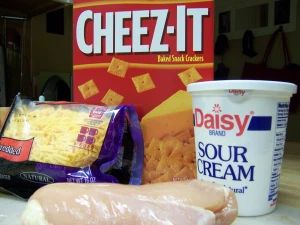 some food is sitting on a counter next to a box of cheez - it