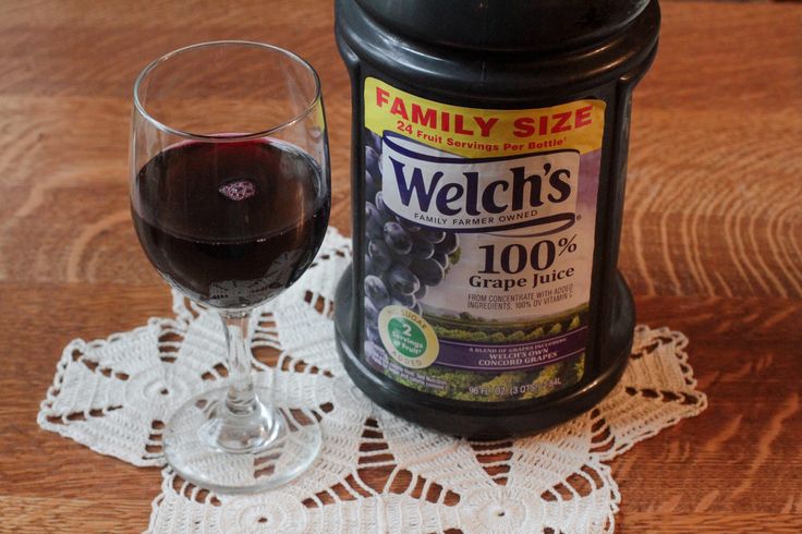 a glass of red wine next to a jar of wehl's on a doily