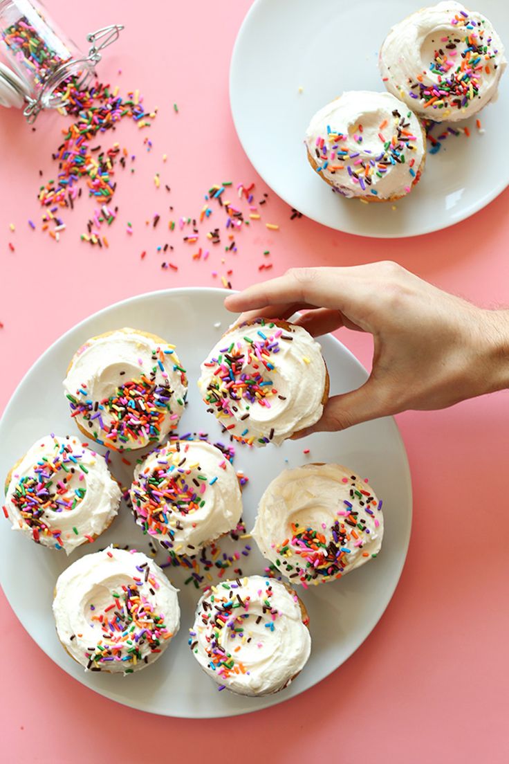 two plates with cupcakes and sprinkles on them