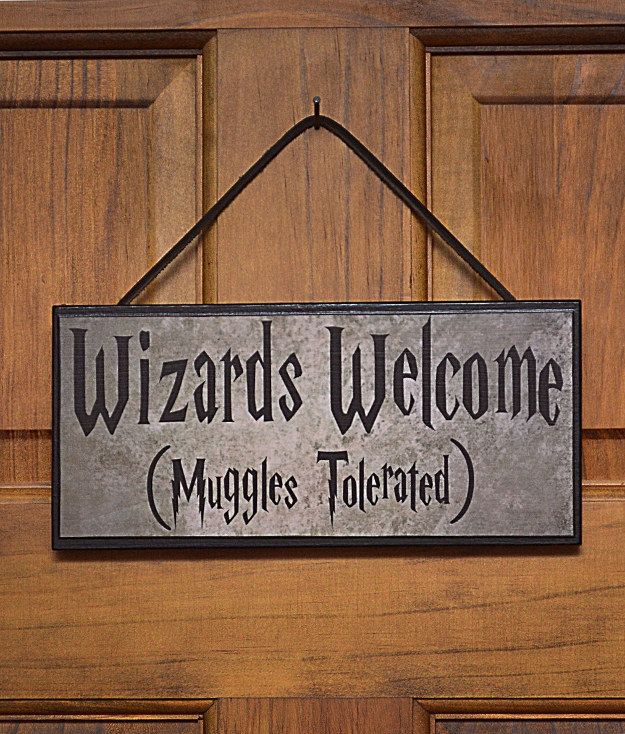 a metal sign hanging on the front door of a house that says wizard's welcome