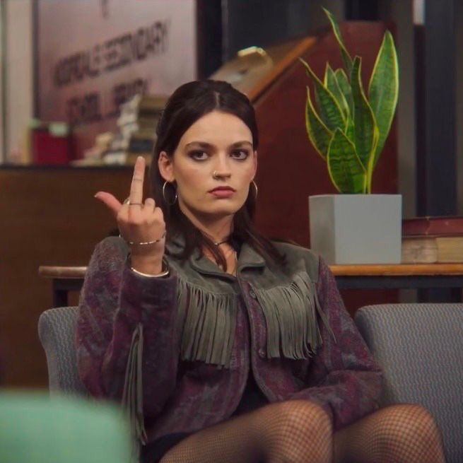 a woman sitting on top of a couch making the peace sign