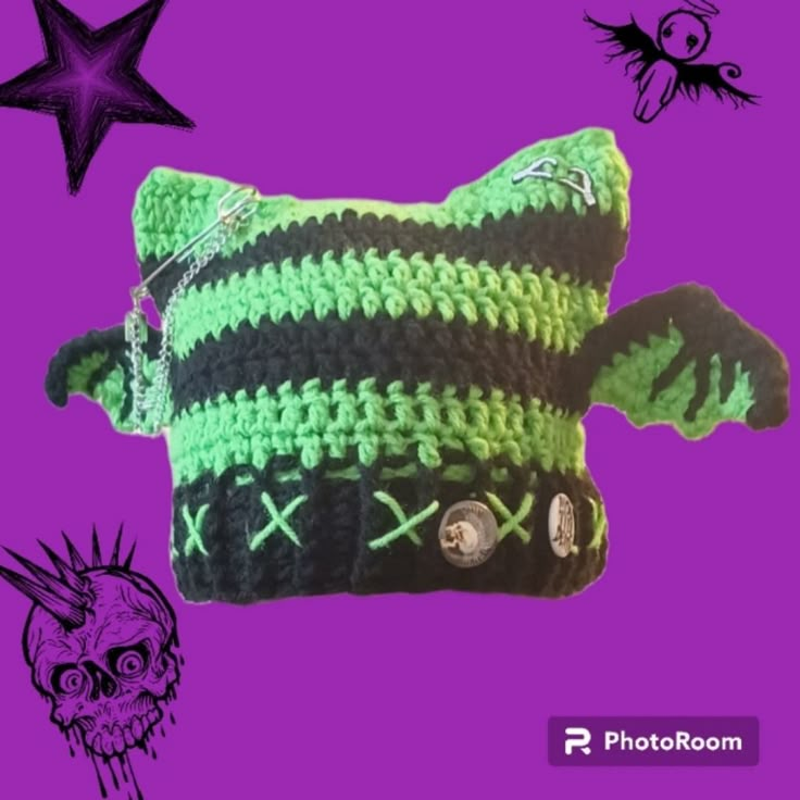 a green and black crocheted bag with a skull on the front, stars in the background