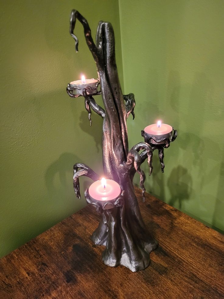 three candles are lit in the center of a tree stump