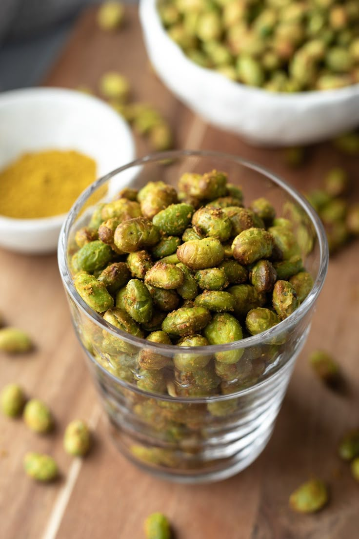 a glass bowl filled with green sprouts and spices