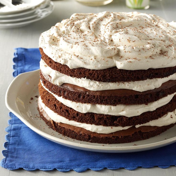 a cake sitting on top of a white plate next to a blue napkin and fork