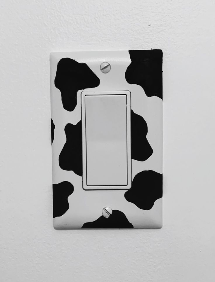 a black and white cow print light switch cover