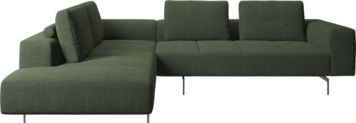 a green sectional sofa with pillows and metal legs