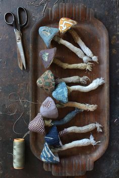 an old tray with several different types of fabric on it and scissors next to it