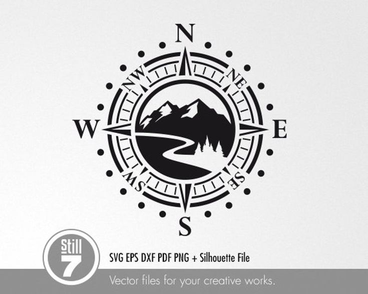 a black and white compass logo with mountains in the background, on a white wall