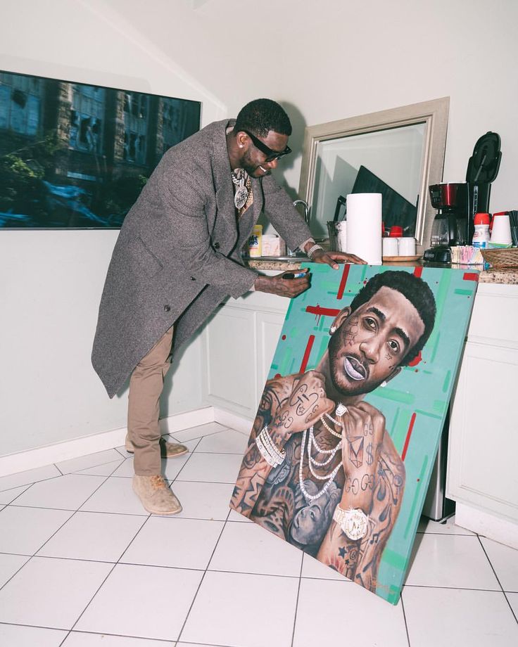 a man standing in front of a painting on the floor