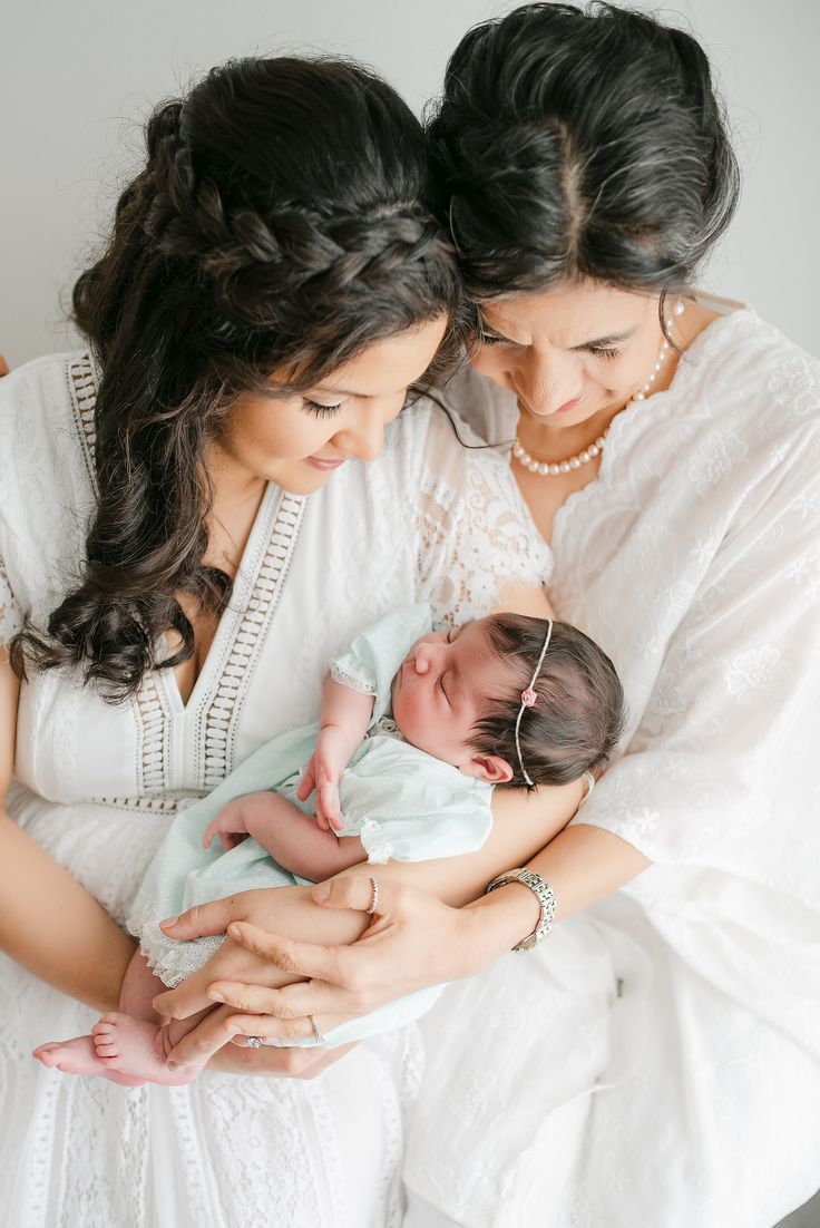 two women holding a baby in their arms