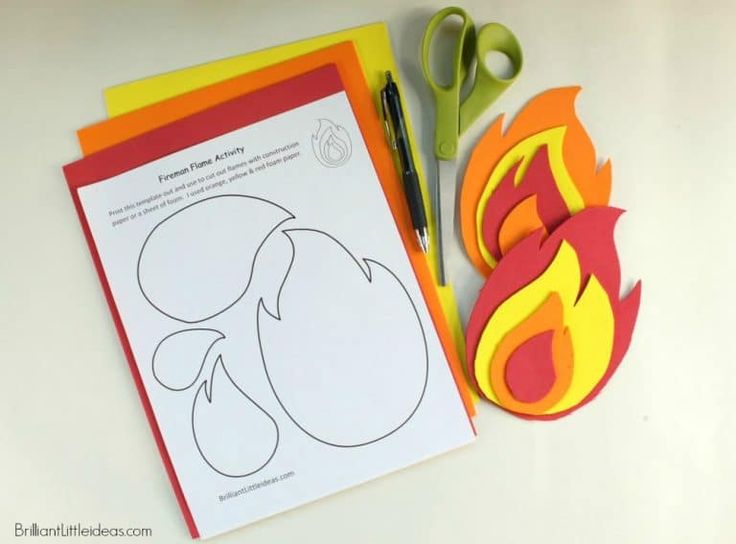 paper cut outs and scissors are on the table next to some crafting supplies that include fire shapes