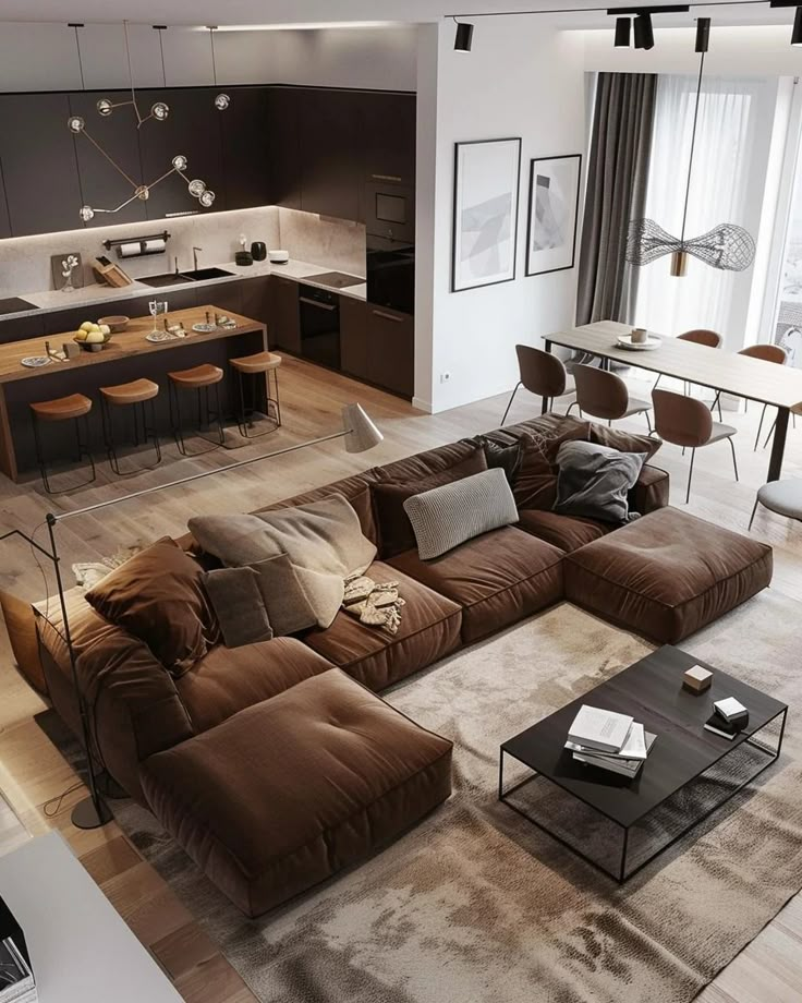 a living room filled with furniture next to a kitchen and dining room table on top of a hard wood floor