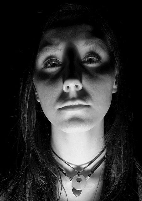 a woman with dark makeup and black make - up on her face wearing a necklace