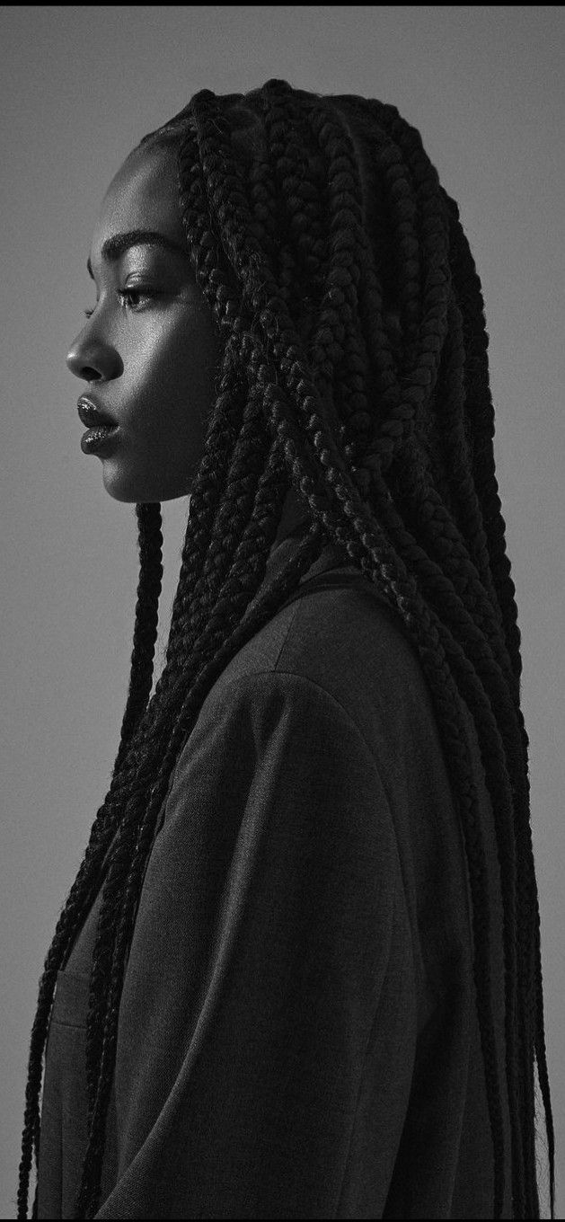 a black and white photo of a woman with long braids