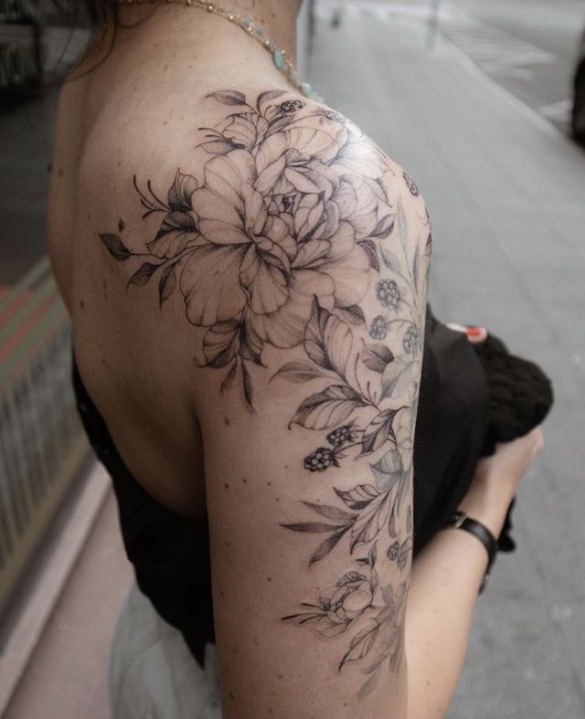 a woman with a flower tattoo on her shoulder