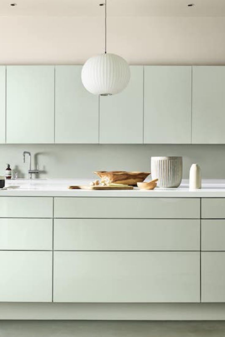 a kitchen filled with lots of white cabinets and counter top space next to a sink