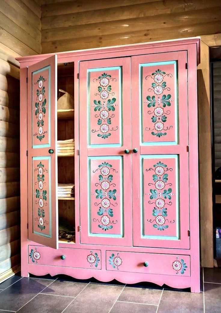 a pink armoire with flowers painted on it