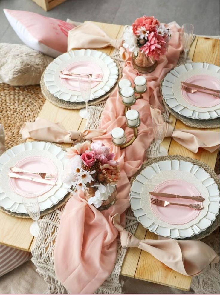 the table is set with pink and white plates