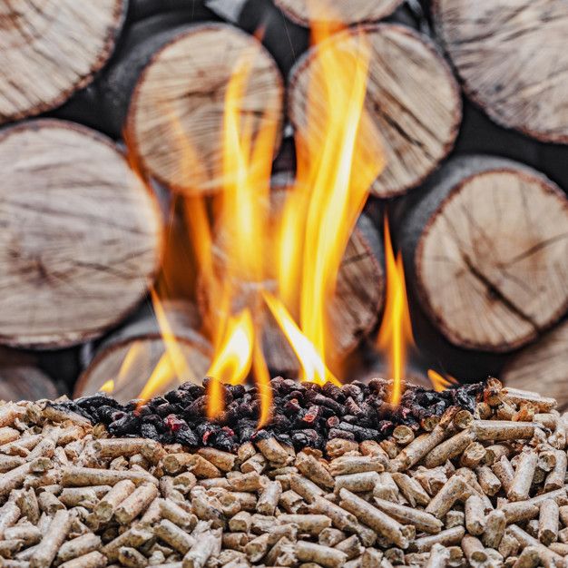 a pile of wood logs sitting next to fire