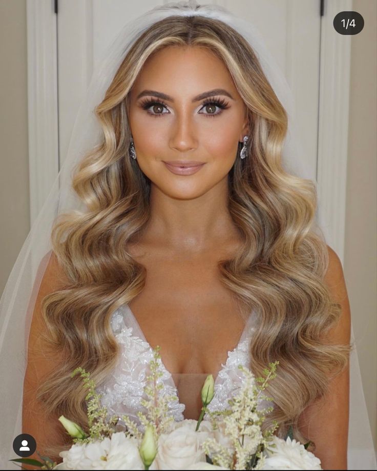 a woman with long blonde hair wearing a wedding dress and holding flowers in her hand