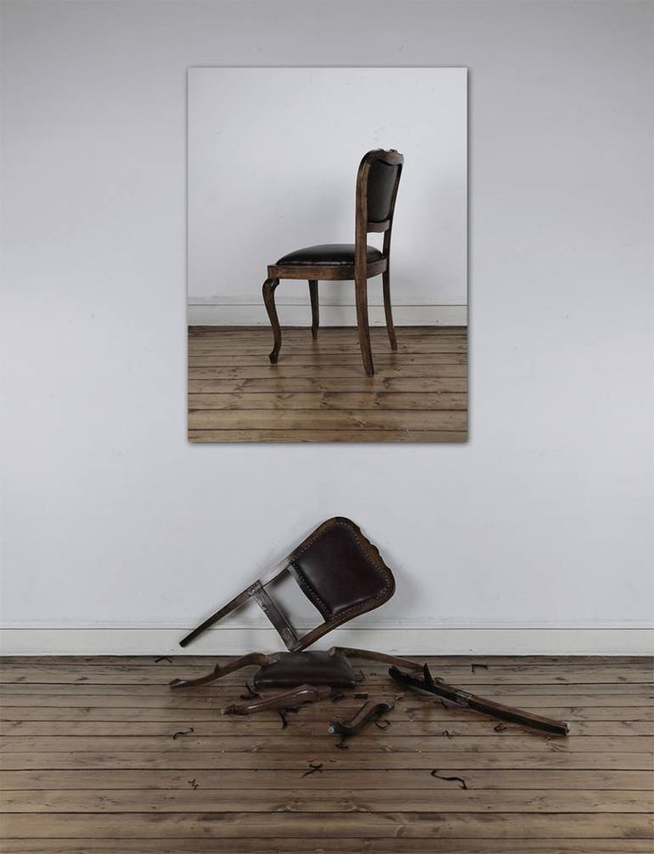 an old chair sitting on top of a hard wood floor next to a broken leg