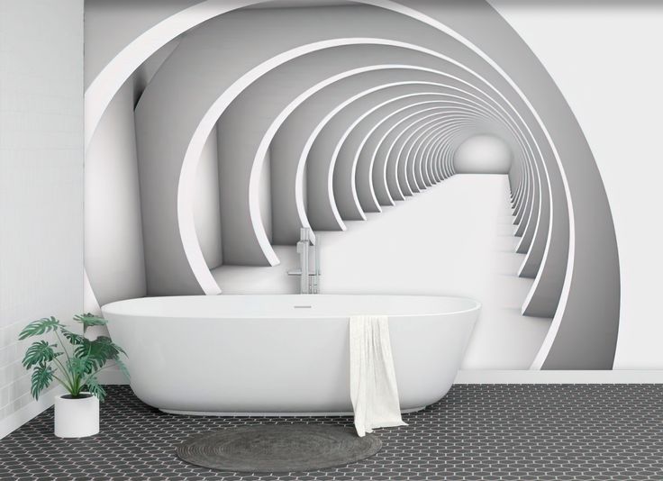 a white bath tub sitting next to a toilet in a bathroom under a wall mural