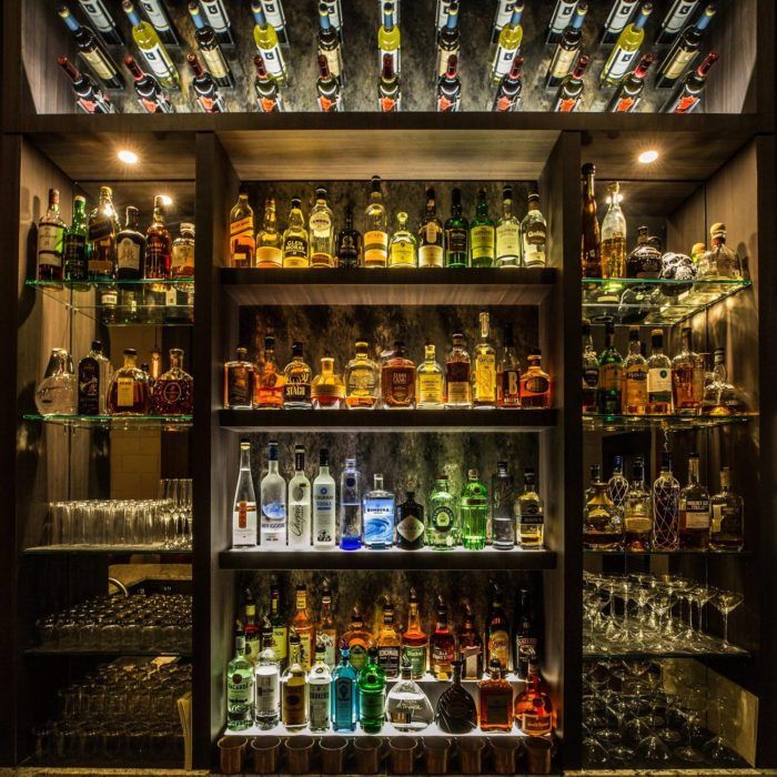 an assortment of liquor bottles and glasses on shelves