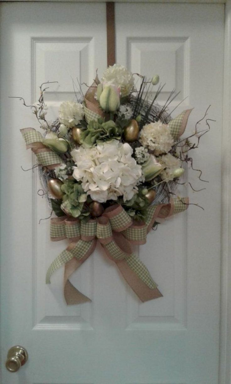 a bouquet of flowers is hanging on the front door to decorate it's entrance