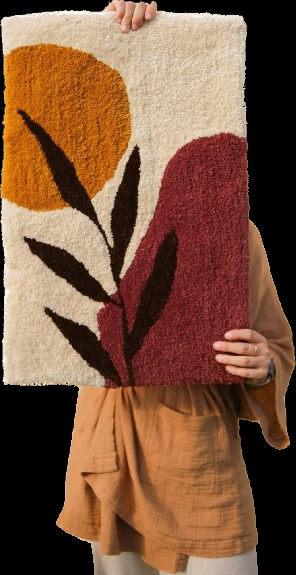 a woman holding up a rug with flowers on it