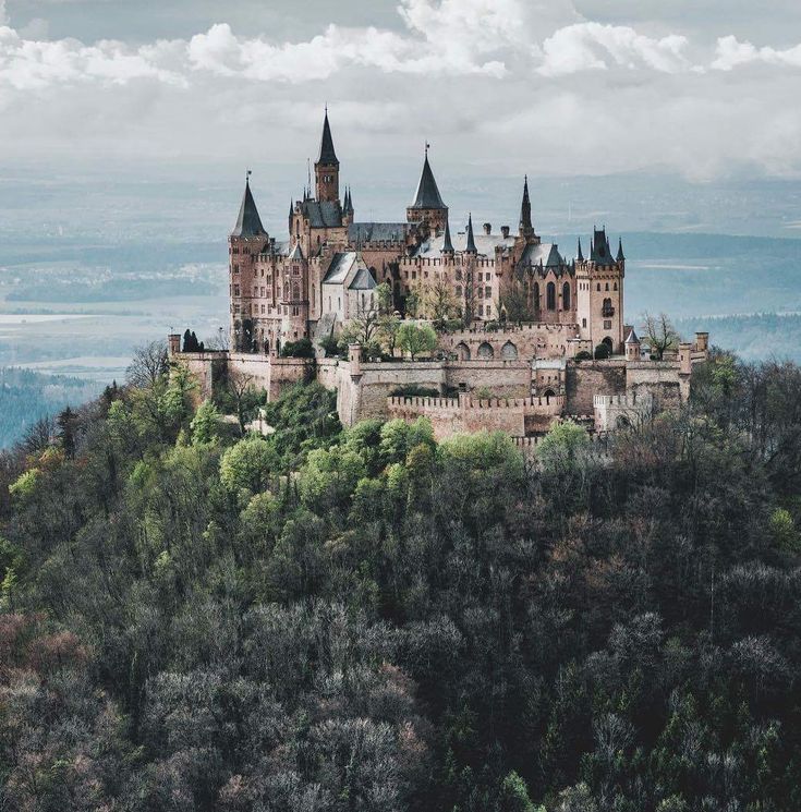 an old castle sitting on top of a lush green hillside