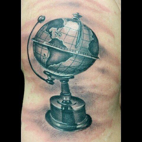 a man's arm with a globe tattoo on it