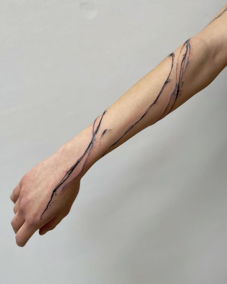 a person with a tattoo on their arm is holding his hand out to the side