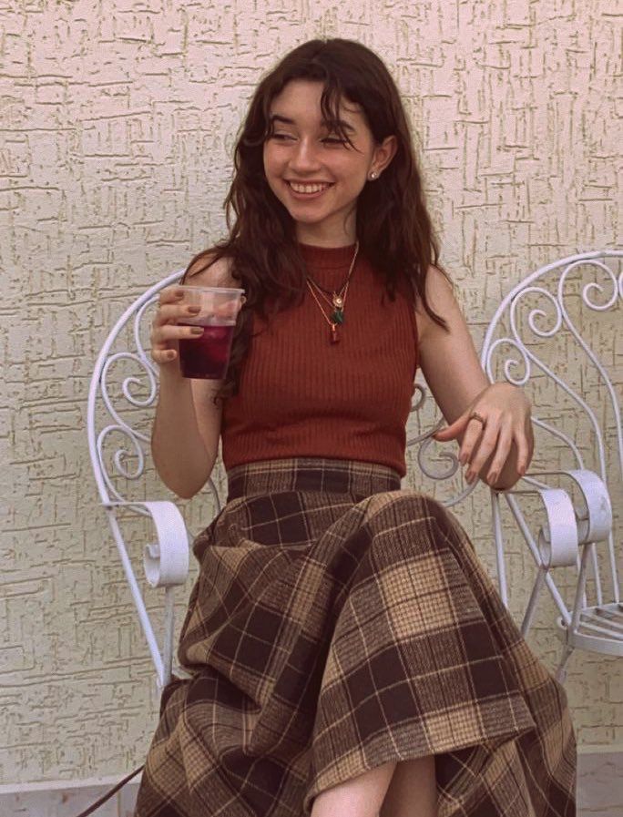 a woman sitting in a chair holding a drink