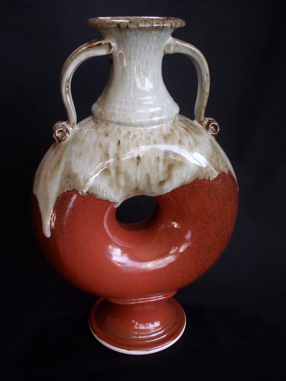 a red and white vase sitting on top of a table