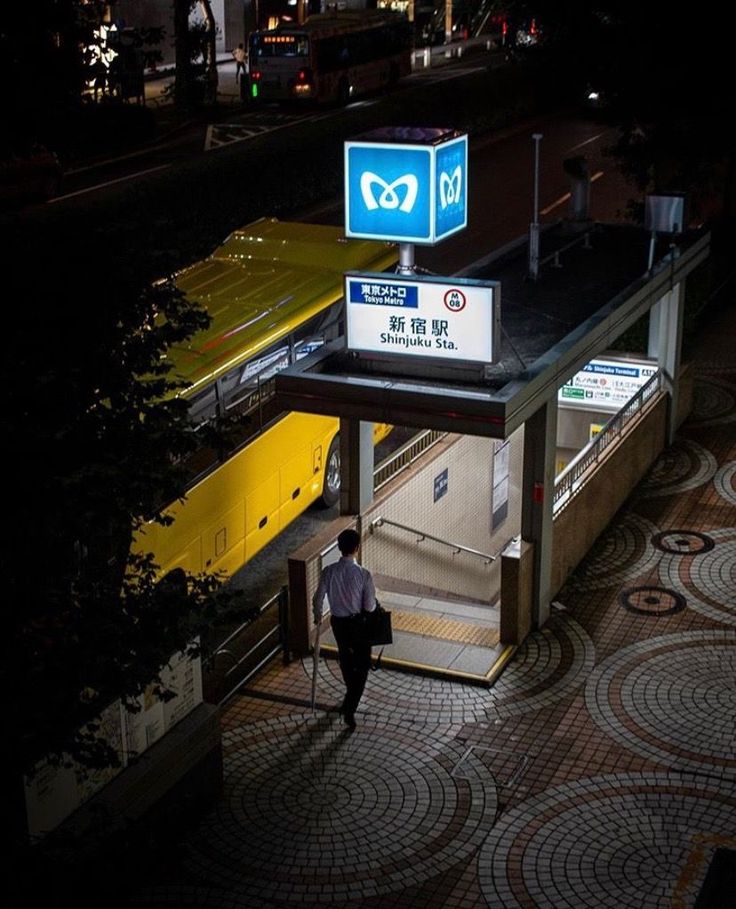 a man is walking up the stairs to an underground train station at night with no one in sight