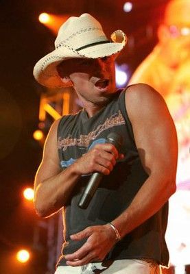 a man in a cowboy hat singing into a microphone