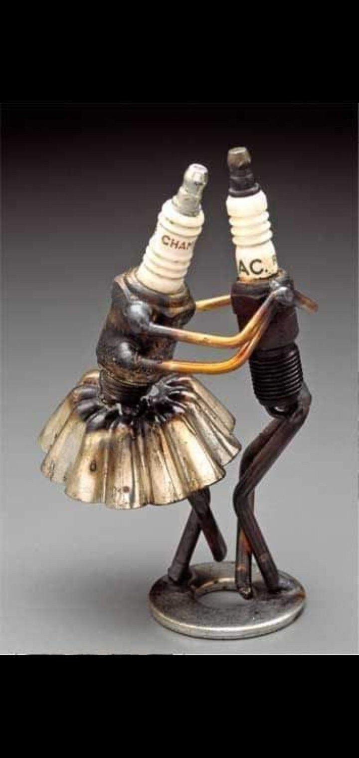 two figurines in the shape of people dancing with bottles on their heads and arms