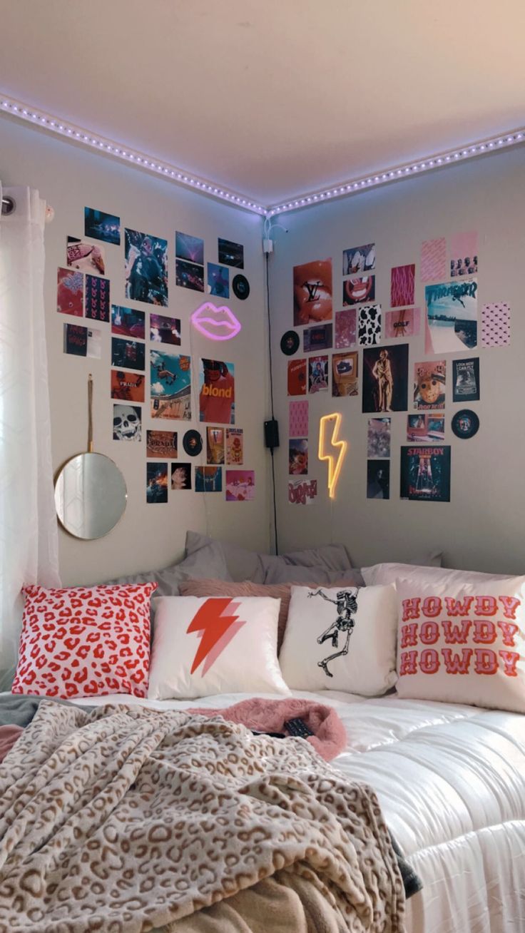 a bed with lots of pillows and pictures on the wall