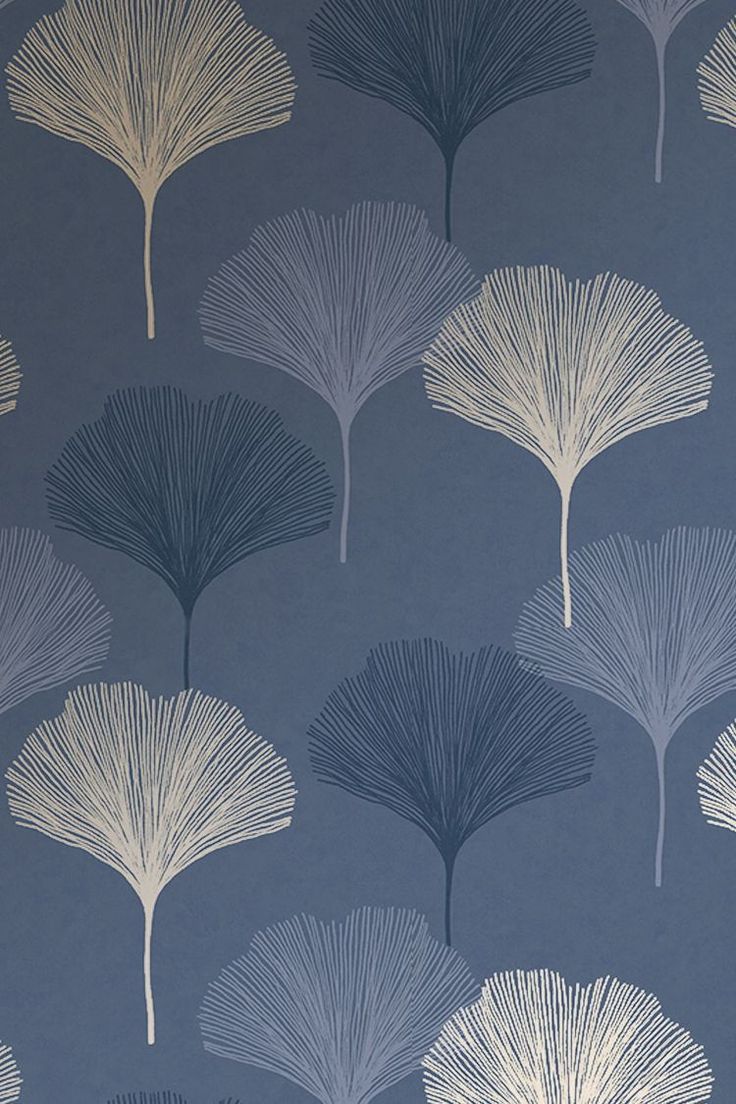 a blue and white wallpaper with large leaves on it