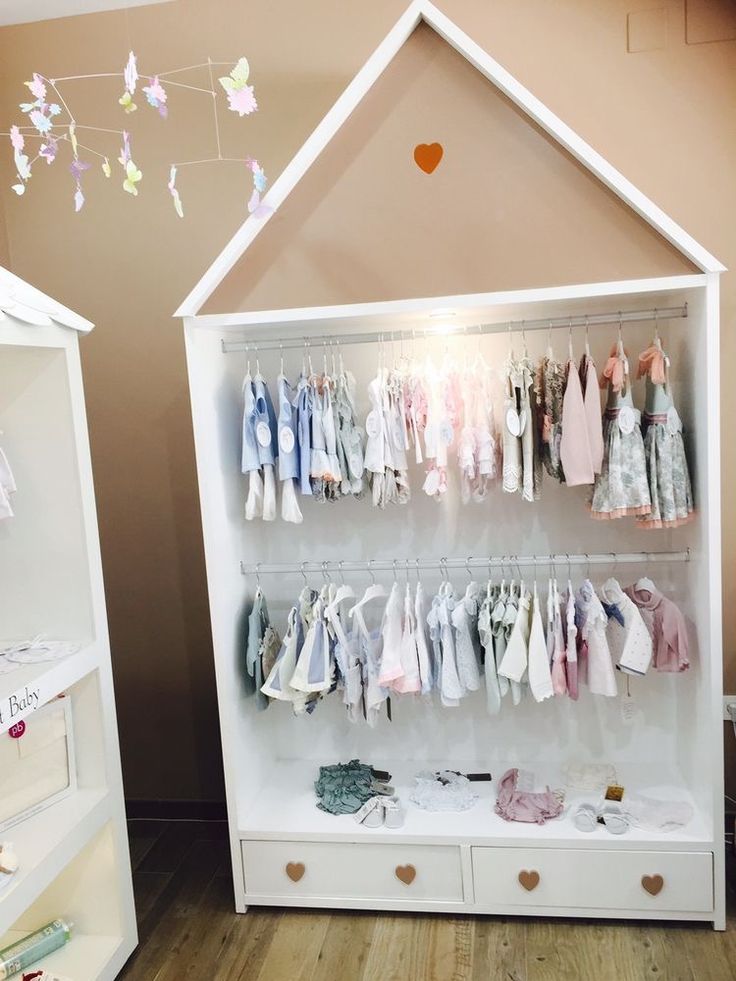 a white cabinet with clothes hanging on it