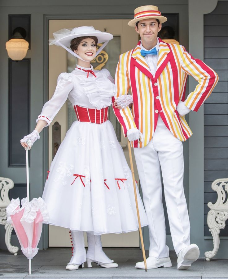 a man and woman dressed in costumes standing next to each other on the front porch