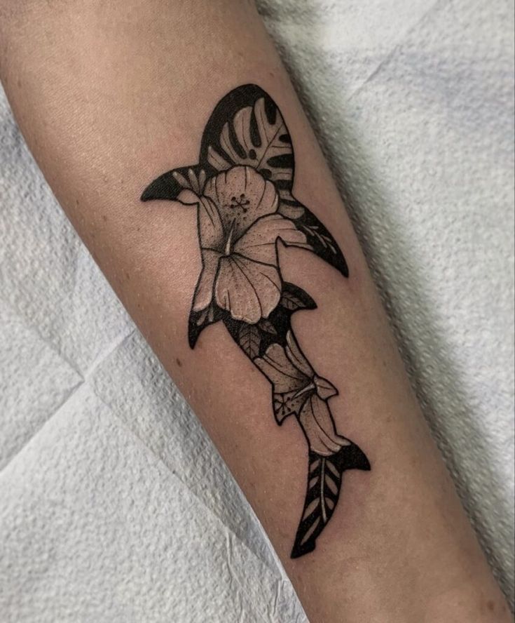 a black and white photo of a fish with flowers on it's side arm