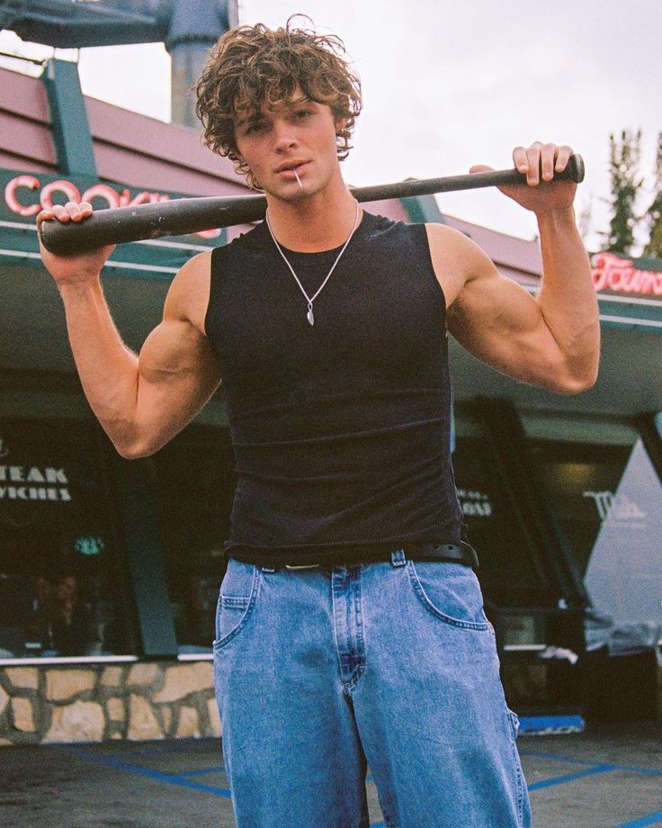 a man holding a baseball bat in front of a building