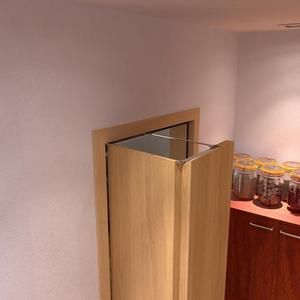 an empty room with some jars on the counter and a wooden cabinet in the corner